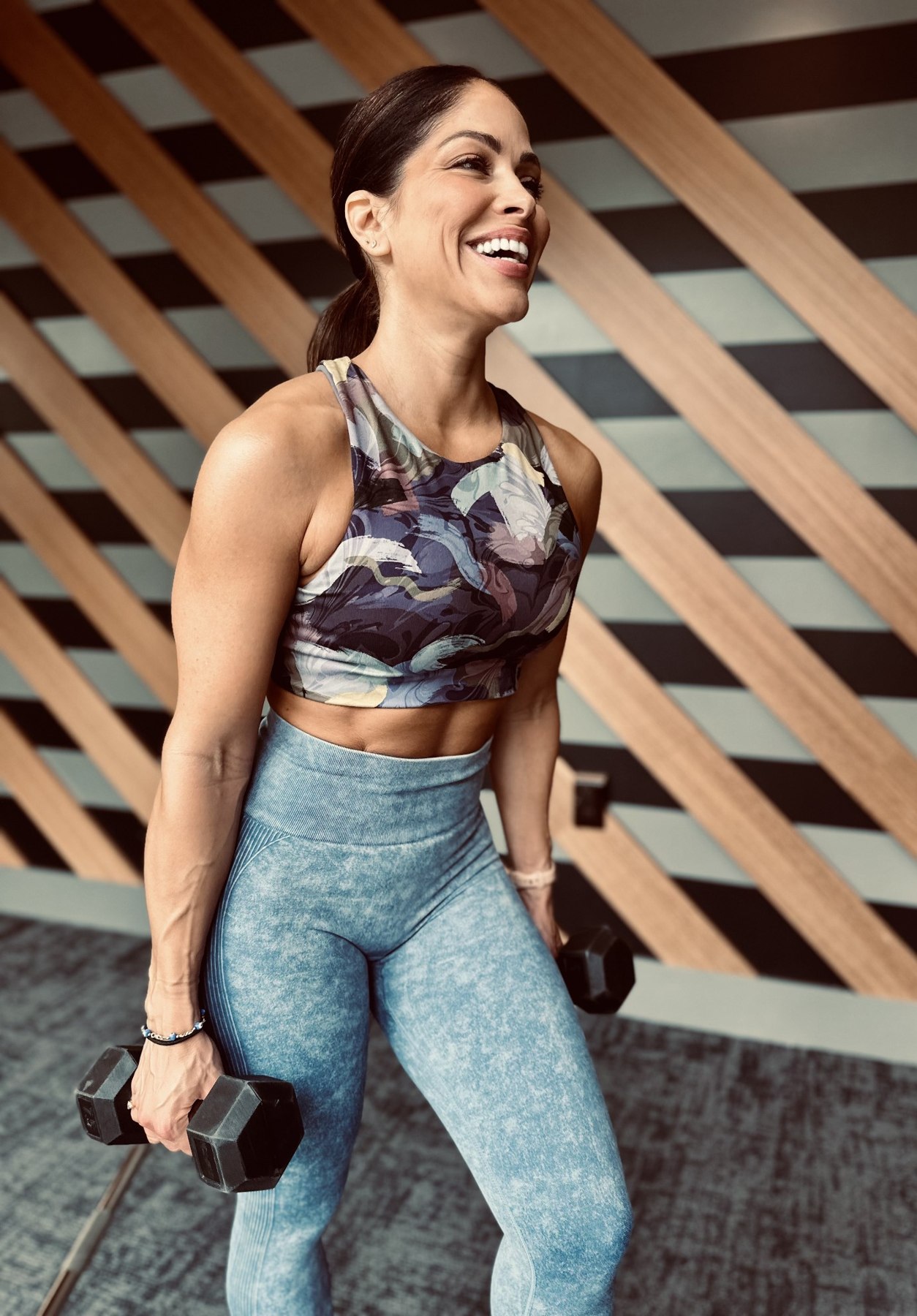 Valery smiling while holding dumbbells
